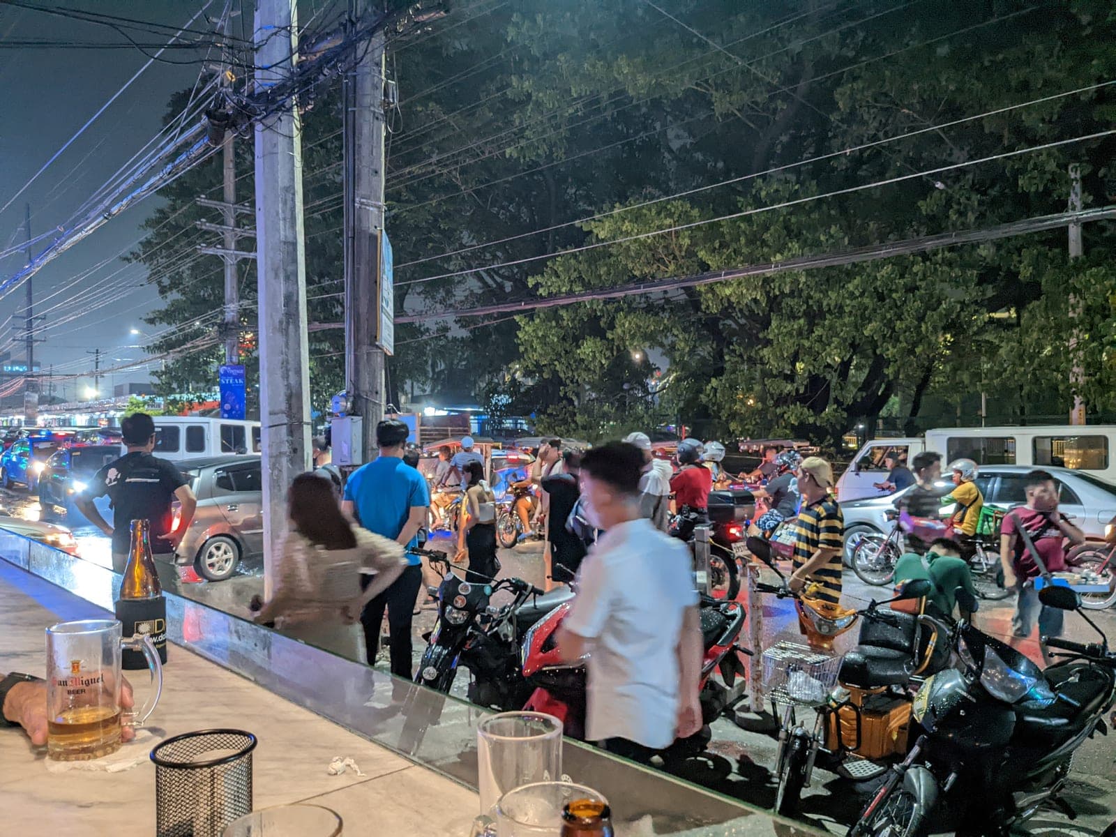 A San Miguel beer on a roadside bar counter on Fields Avenue, Angeles City, with tricycles and motorbikes passing